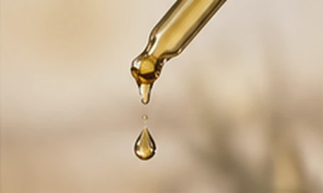 Glass pipette with a golden drop — Editorial illustration